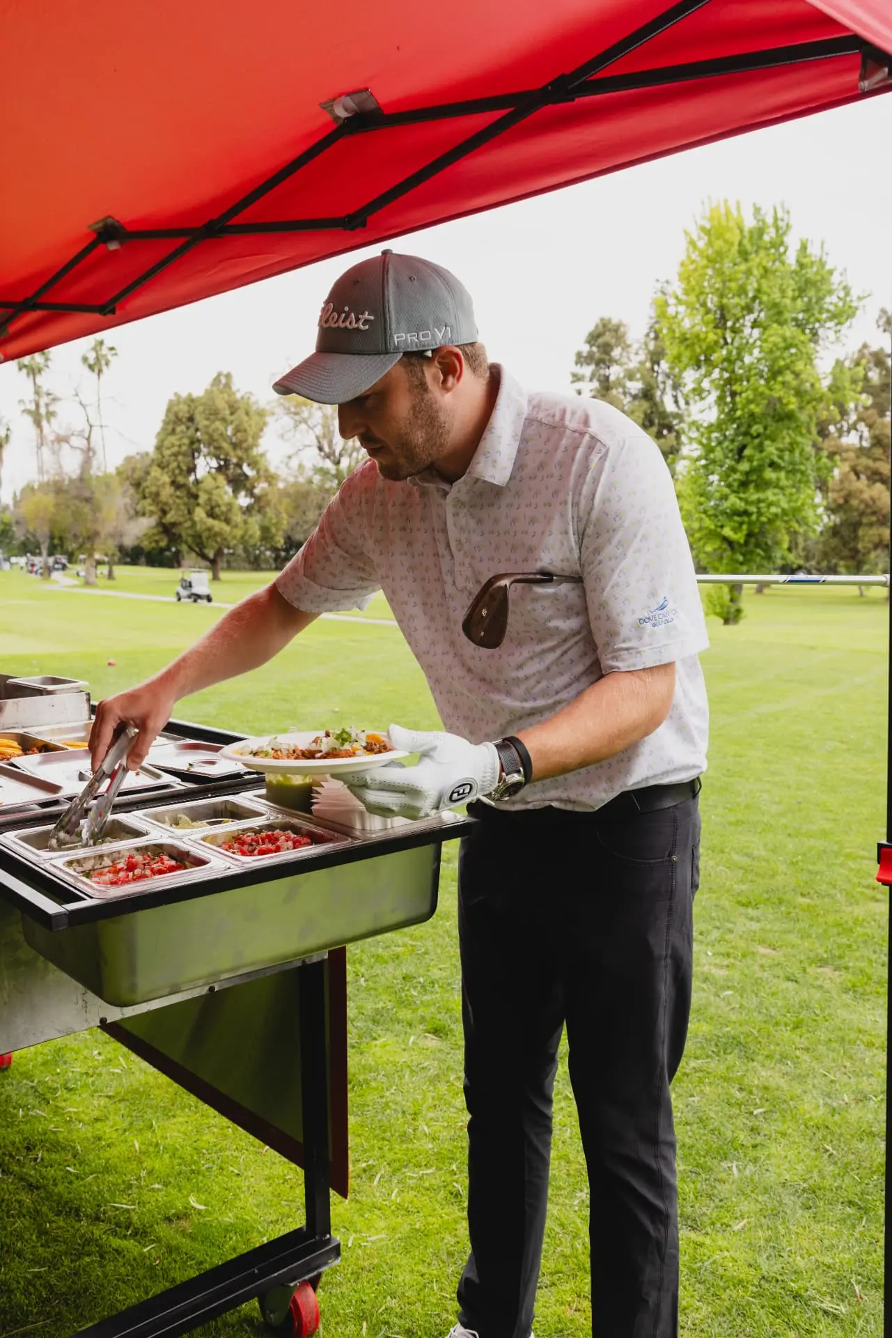 Guest serving themselves from Big Art's catering setup at an outdoor event